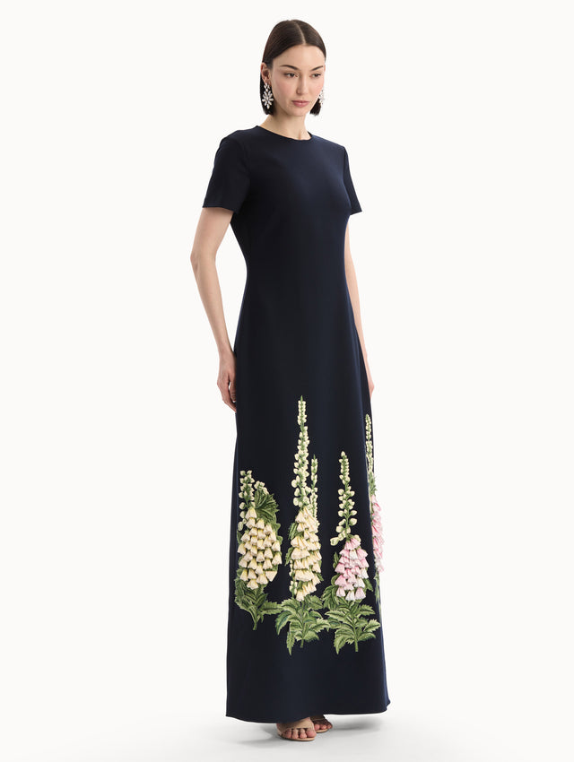 The model is wearing the Foxglove Embroidered Caftan in Navy with  three-dimensional threadwork embroidery. Side View.