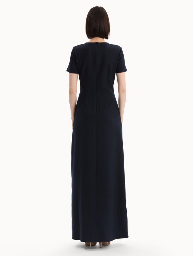 The model is wearing the Foxglove Embroidered Caftan in Navy with  three-dimensional threadwork embroidery. Back View.