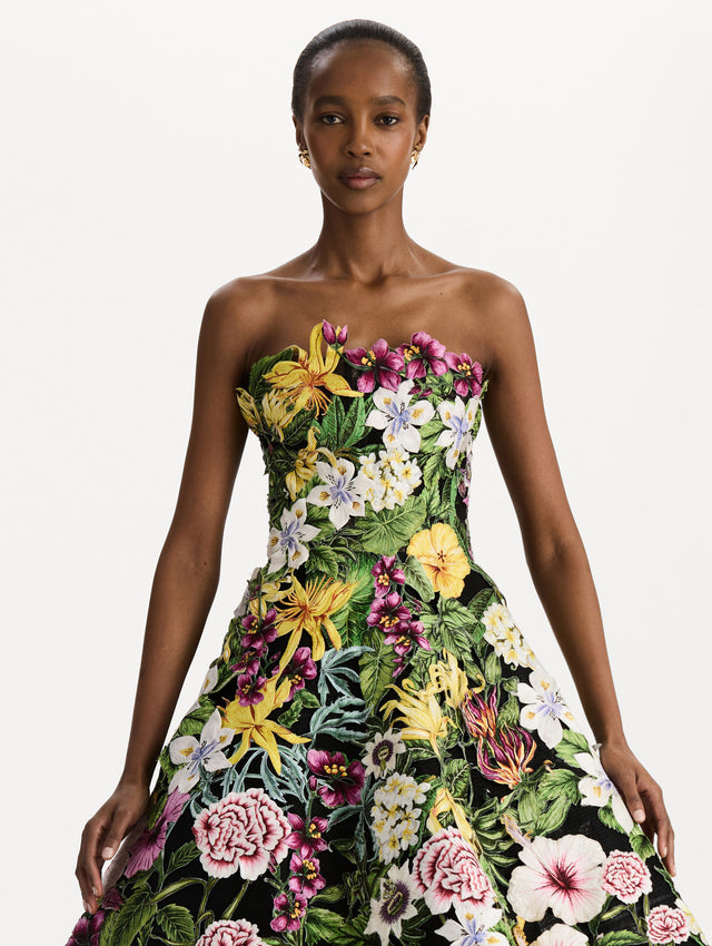 The model is wearing the Dominican Mixed-Floral Guipure Gown. Featuring a strapless neckline, fitted bodice, and full skirt. Detail View.