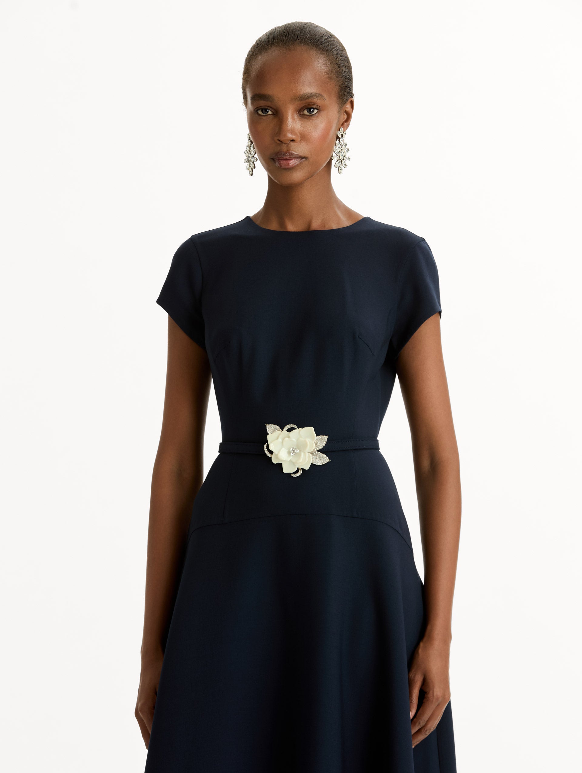 Navy Floral Belt Short Sleeve Dress with short sleeves and a belted waist featuring a white floral accent. Zoom View.