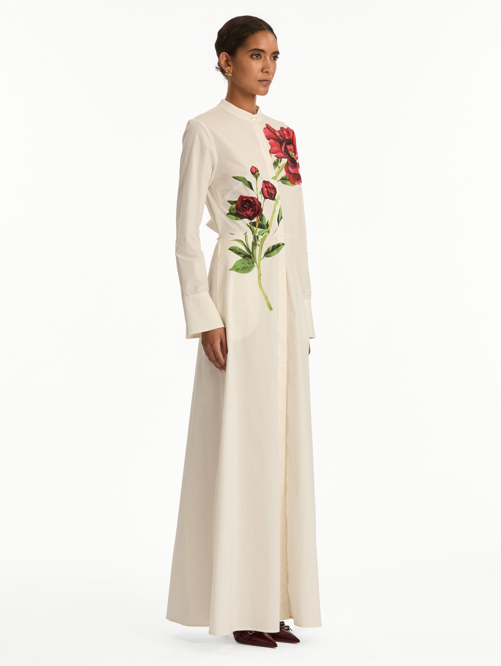 White long sleeve dress with printed pink peonies on bodice and self-tie closure along the waist. Side View.