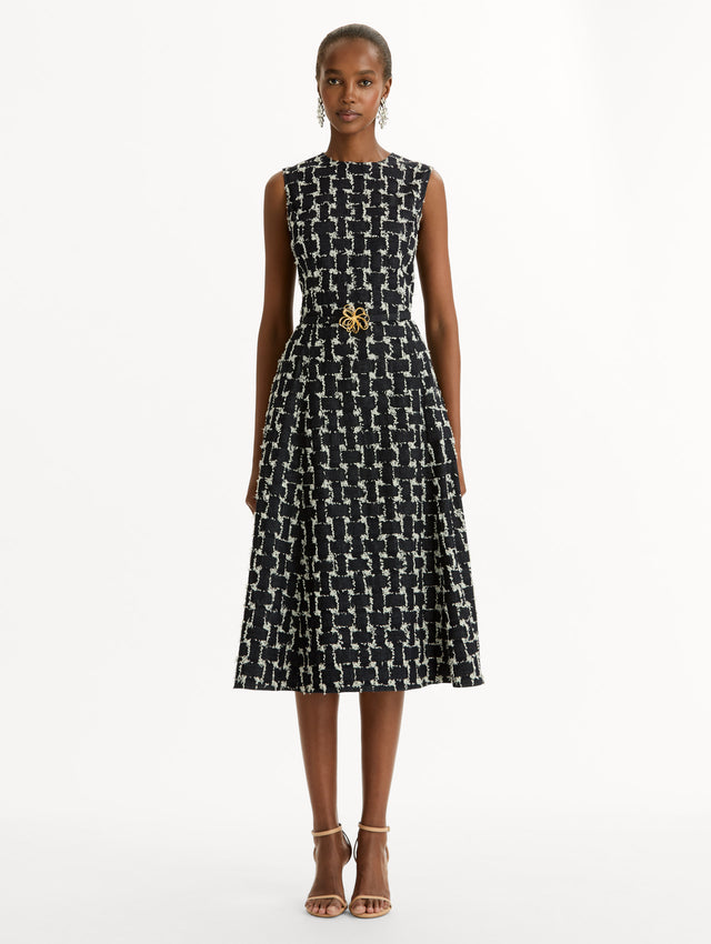 Black and Ivory Woven Denim Jacquard Midi Dress featuring a pleated skirt and belted waist with gold flower detail. Front View.