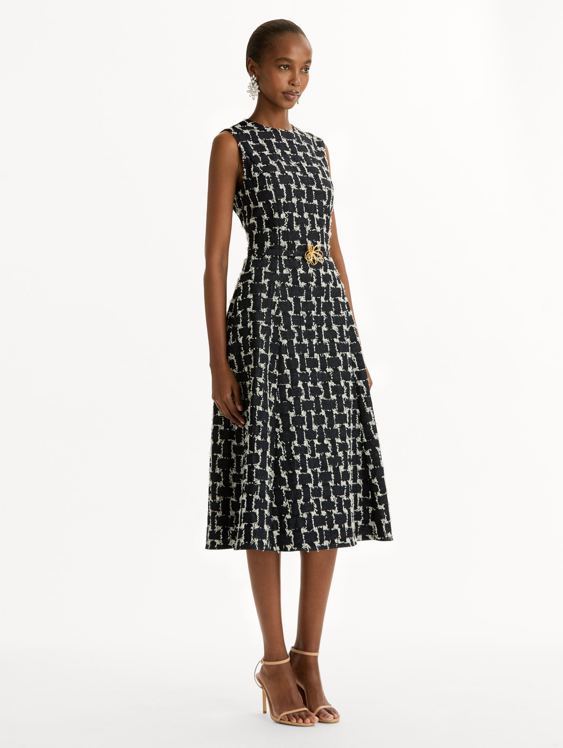 Black and Ivory Woven Denim Jacquard Midi Dress featuring a pleated skirt and belted waist with gold flower detail. Side View.