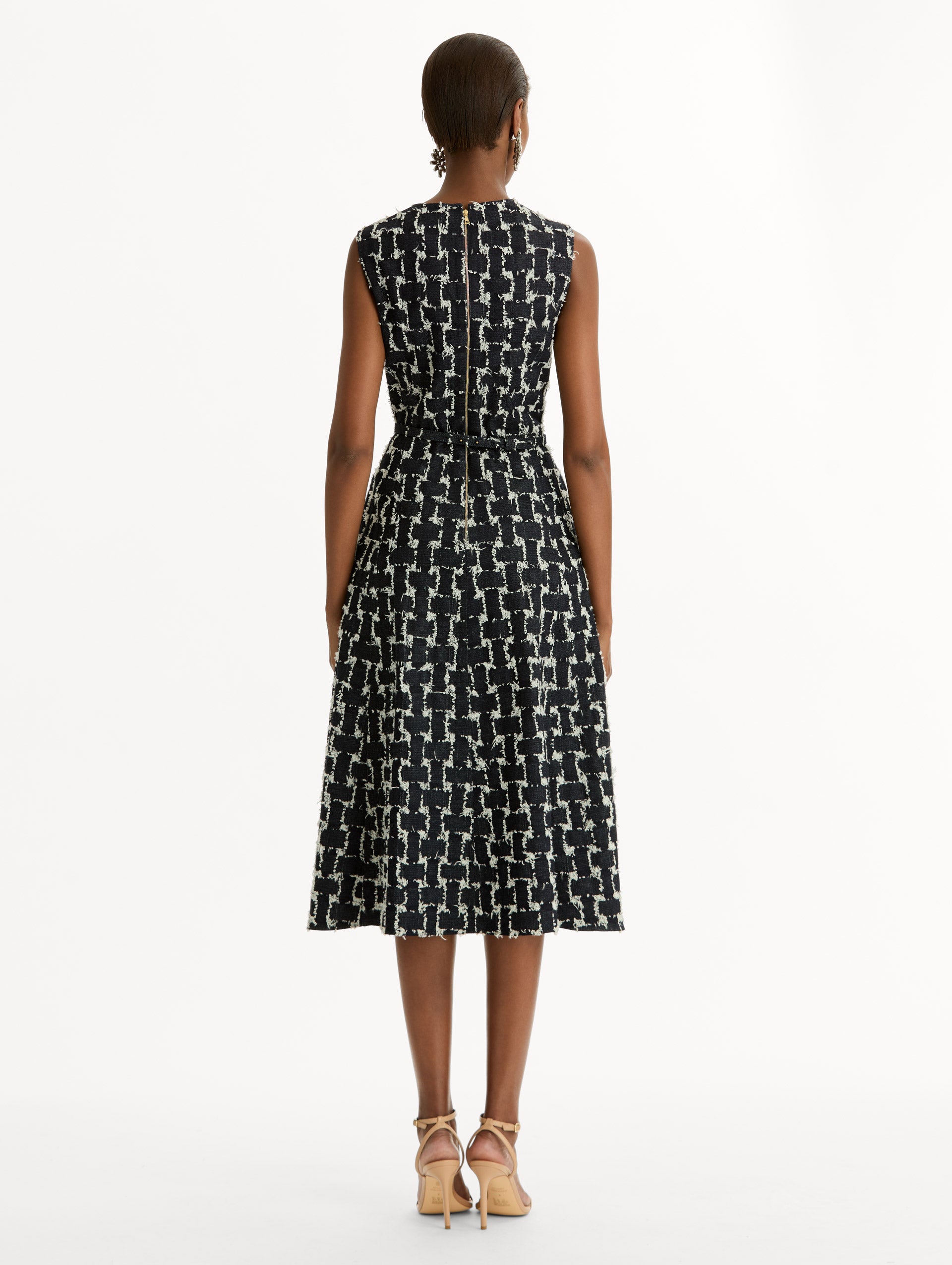 Black and Ivory Woven Denim Jacquard Midi Dress featuring a pleated skirt and belted waist with gold flower detail. Back View.