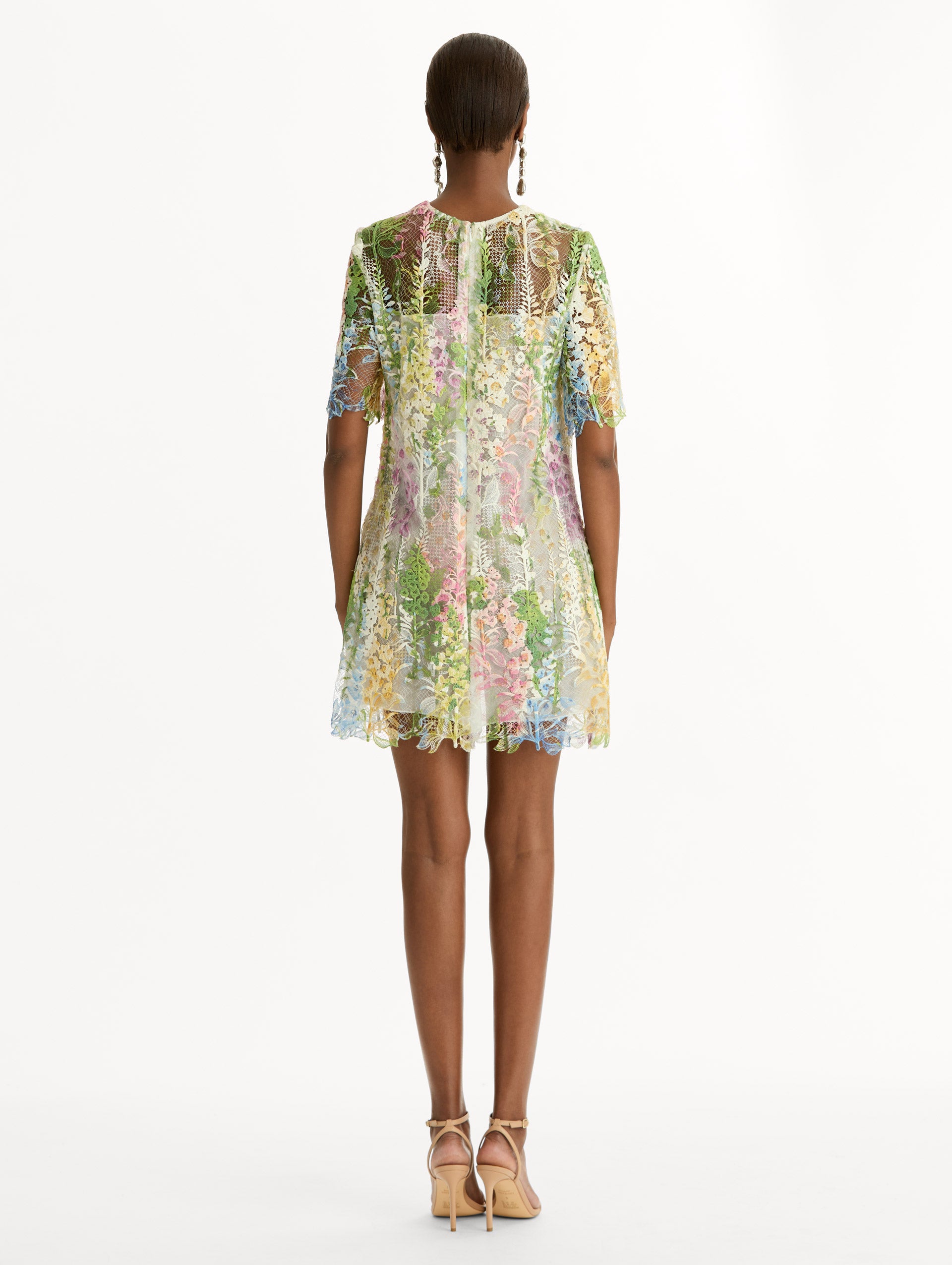 White and floral Foxglove Guipure Shift Dress with multi color sheer floral overlay and a white lining underneath. Back View.