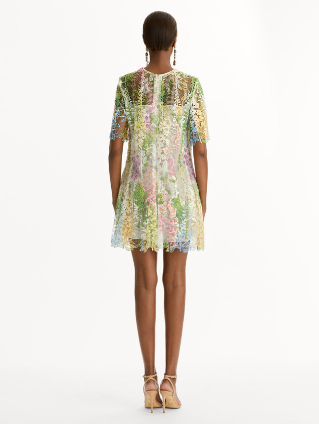 White and floral Foxglove Guipure Shift Dress with multi color sheer floral overlay and a white lining underneath. Back View.