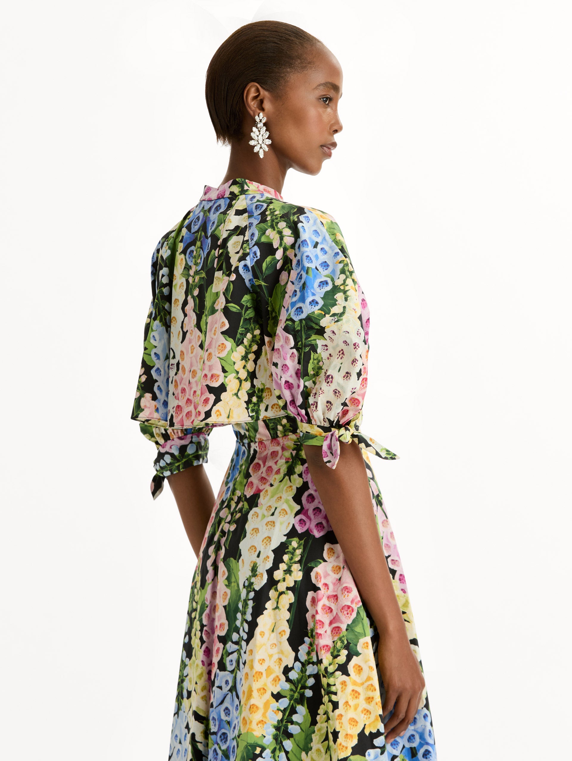 Black floral Foxglove Cotton Poplin Puff Sleeve Dress with voluminous elbow-length puff sleeves, a fitted waist, and a flared skirt that falls below the knee. Zoom View.
