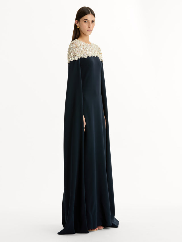 Navy Mother of Pearl Embroidered Caftan with ivory embroidered neckline and floor-length draped silhouette. Side View.