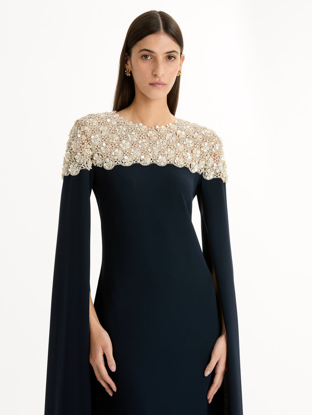 Navy Mother of Pearl Embroidered Caftan with ivory embroidered neckline and floor-length draped silhouette. Zoom View.