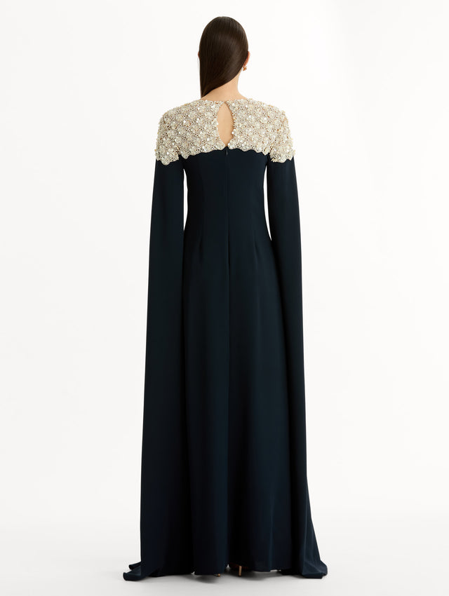 Navy Mother of Pearl Embroidered Caftan with ivory embroidered neckline and floor-length draped silhouette. Back View.