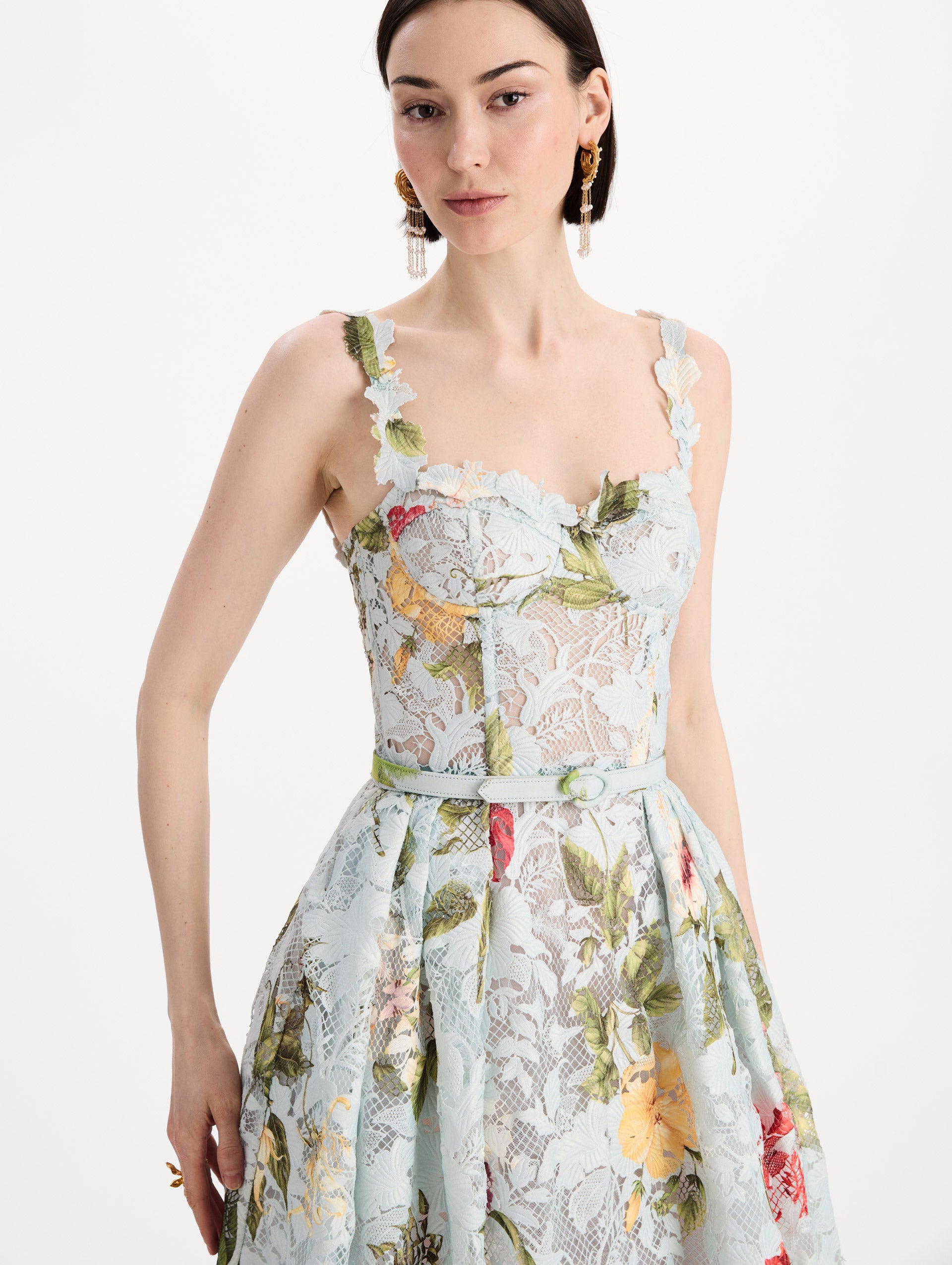 The model is wearing the Dominican Mixed-Floral Guipure Cocktail Dress in Saltwater Blue. Featuring floral detailing on straps, sweetheart neckline, structured bodice, and full skirt. Detail View.