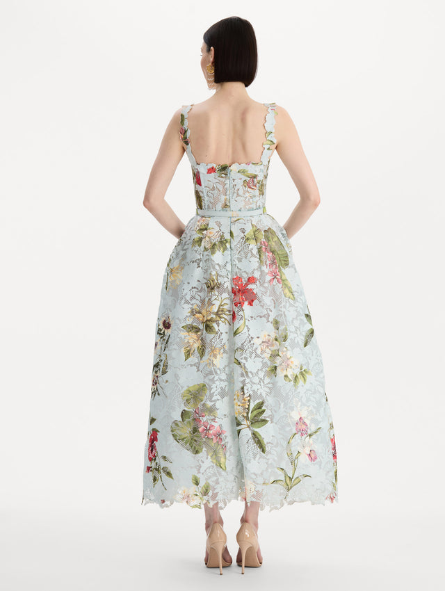 The model is wearing the Dominican Mixed-Floral Guipure Cocktail Dress in Saltwater Blue. Featuring floral detailing on straps, sweetheart neckline, structured bodice, and full skirt. Back View.