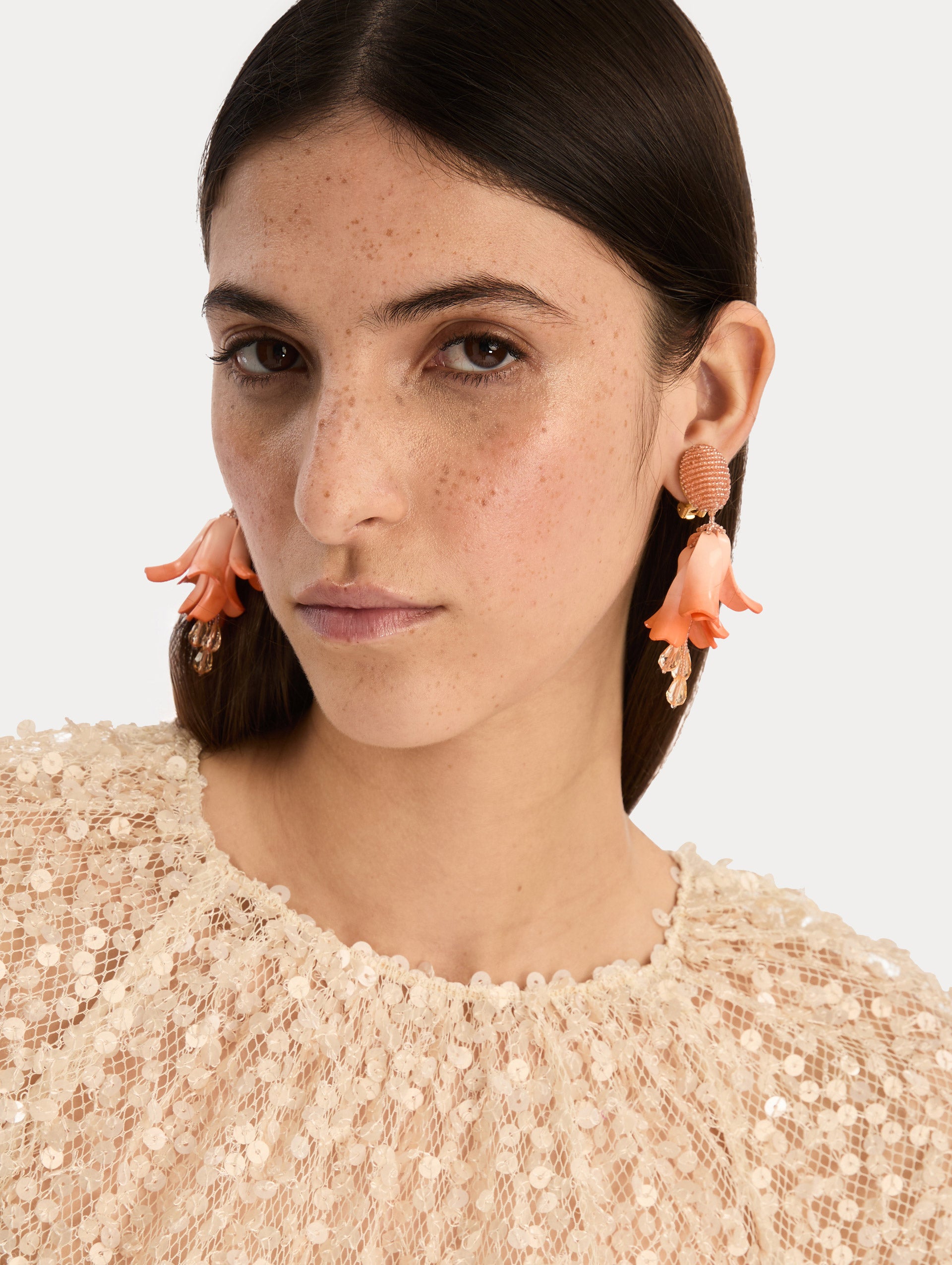 Coral Impatiens Clip-On Earrings with circular beaded studs and sculpted petal drops. Front View.