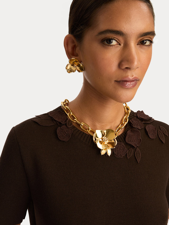 Gold Blossom Chain-Link Necklace featuring a sculpted floral charm with crystal center accents. Front View.