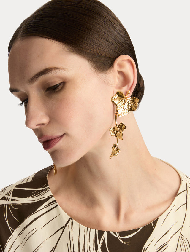 Gold Ivy Vine Drop Clip-On Earrings featuring sculpted ivy leaves along a curved drop design. Side View.