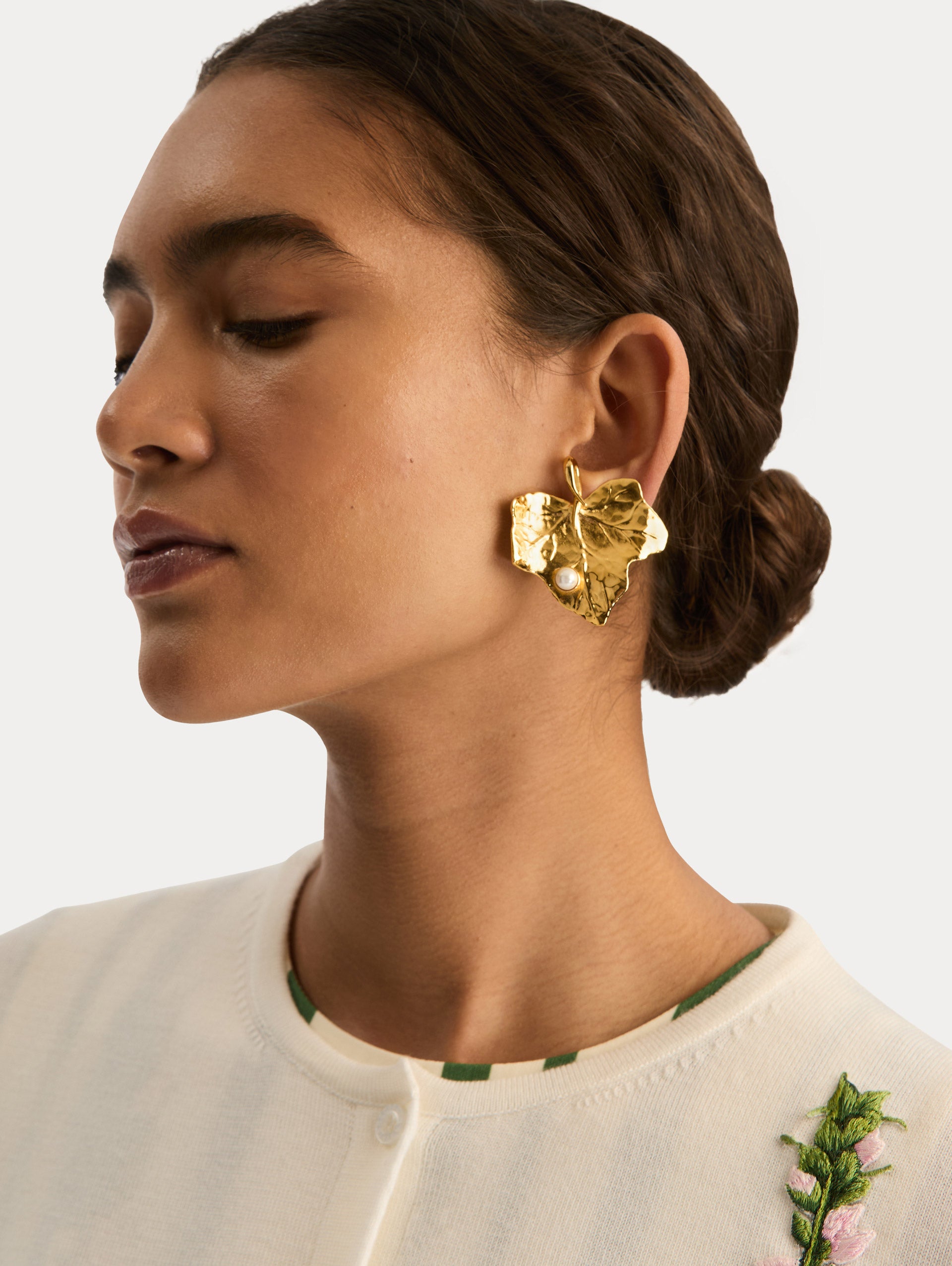 Gold Ivy Leaf Earrings featuring a textured finish and accented with a single small pearl at the base. Side View.