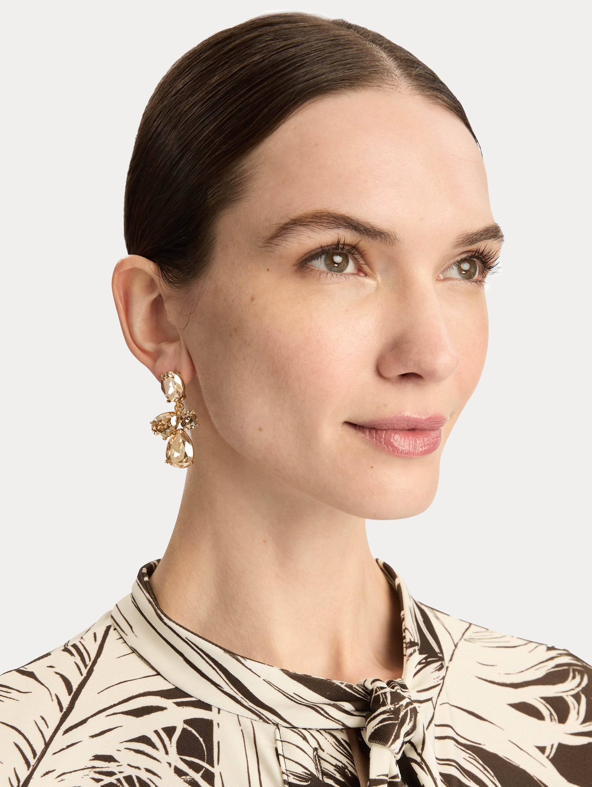 Gold Candy Drop Earrings featuring champagne oval studs, clear round crystals, and faceted teardrop pendants. Front View.