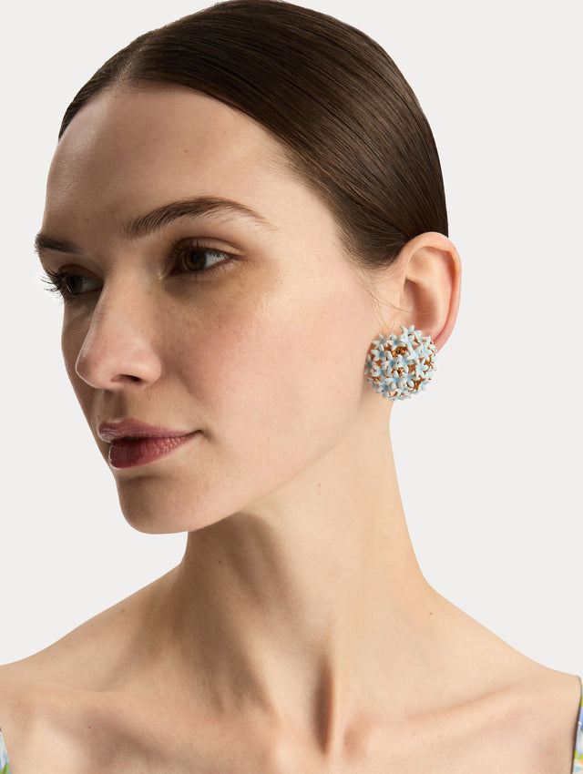 Light blue Small Foxglove Pompom Clip-On Earrings featuring gold settings with enamel blossoms. Front View.