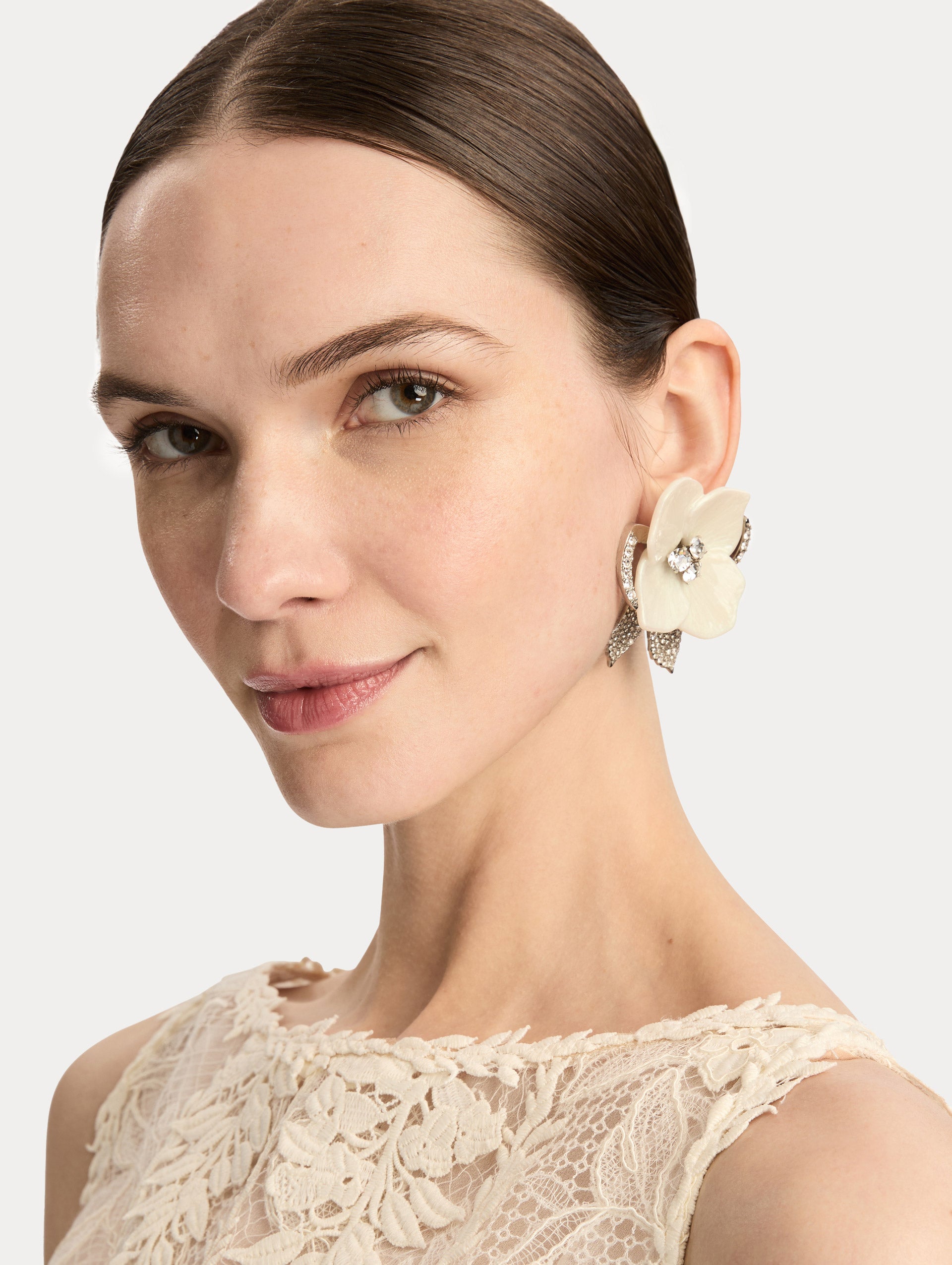 White and silver Pearl Blossom Clip-On Earrings featuring enamel petals, crystal centers, and pavé leaf accents. Front View.