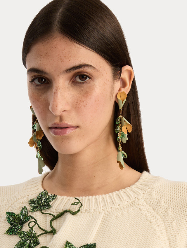 Gold and green Bellflower Drop Earrings featuring layered petal motifs with emerald crystal accents. Front View.