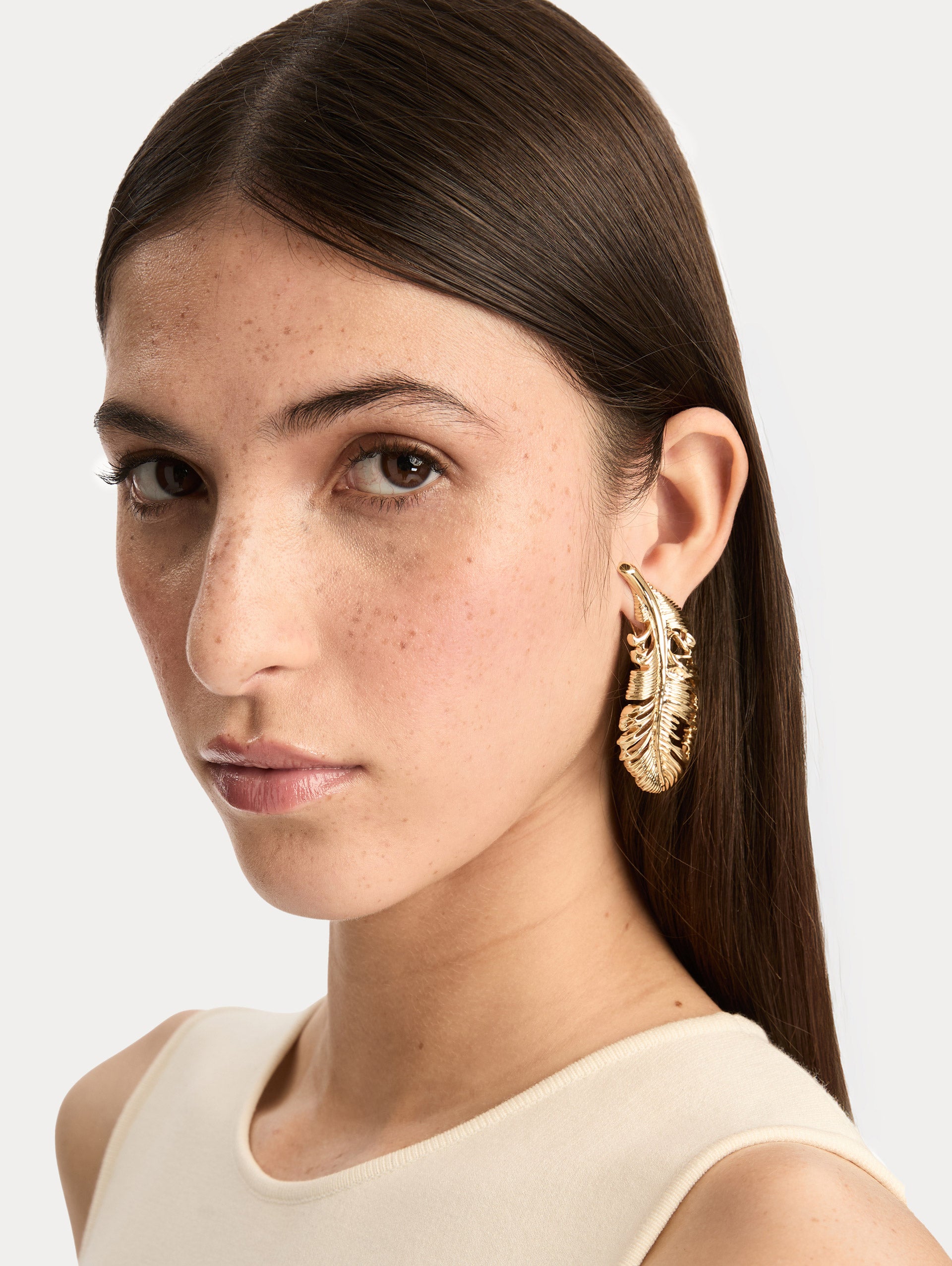 Gold Feather Clip-On Earrings featuring an openwork design with textured detailing. Front View.