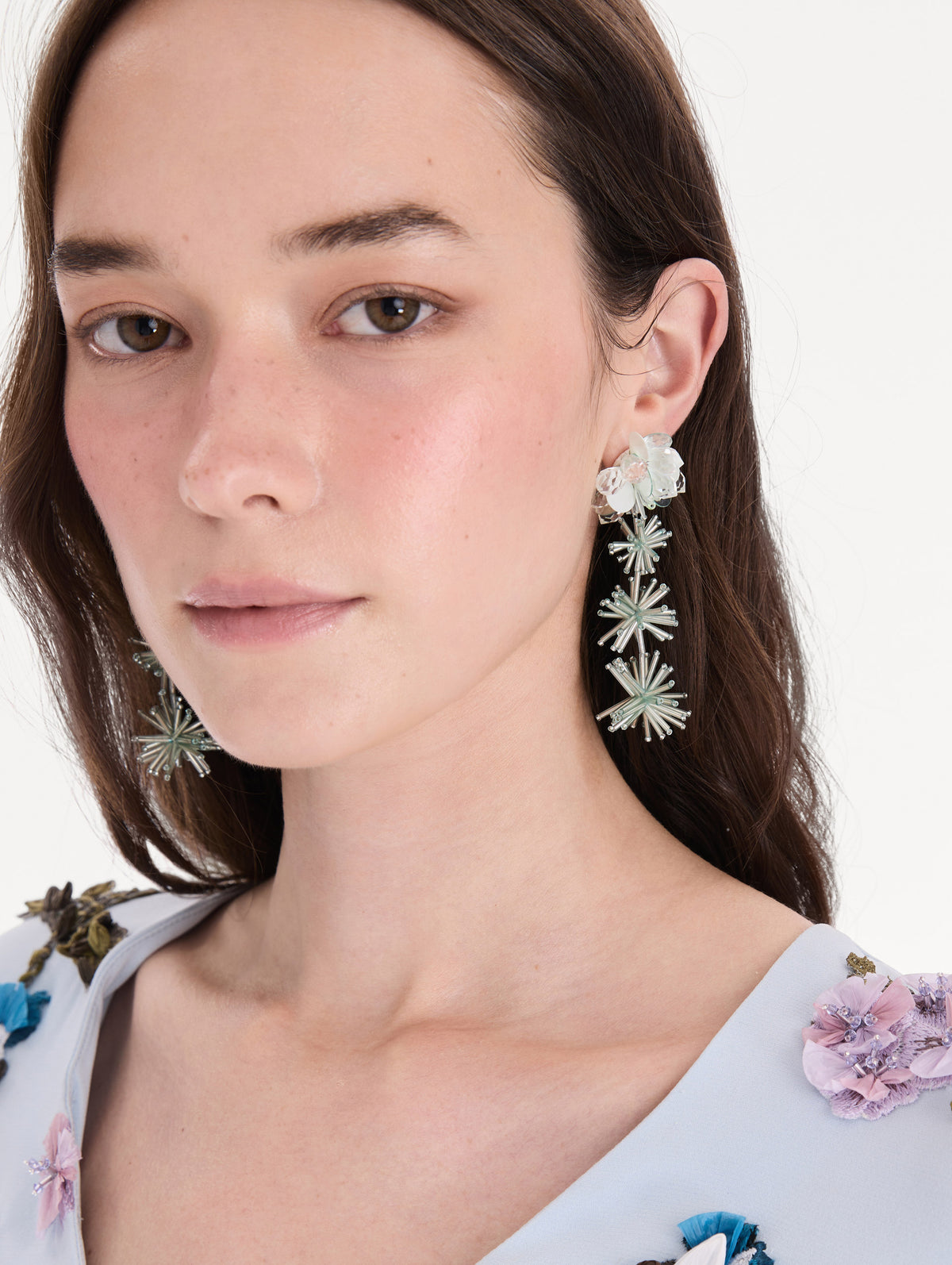 The model is wearing bugle bead firework drop earrings. Front view.