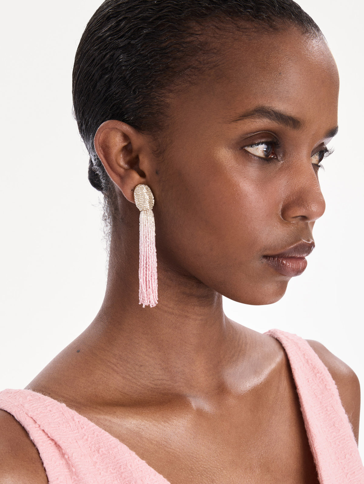 The model is wearing ombre beaded tassel earrings. Front view.