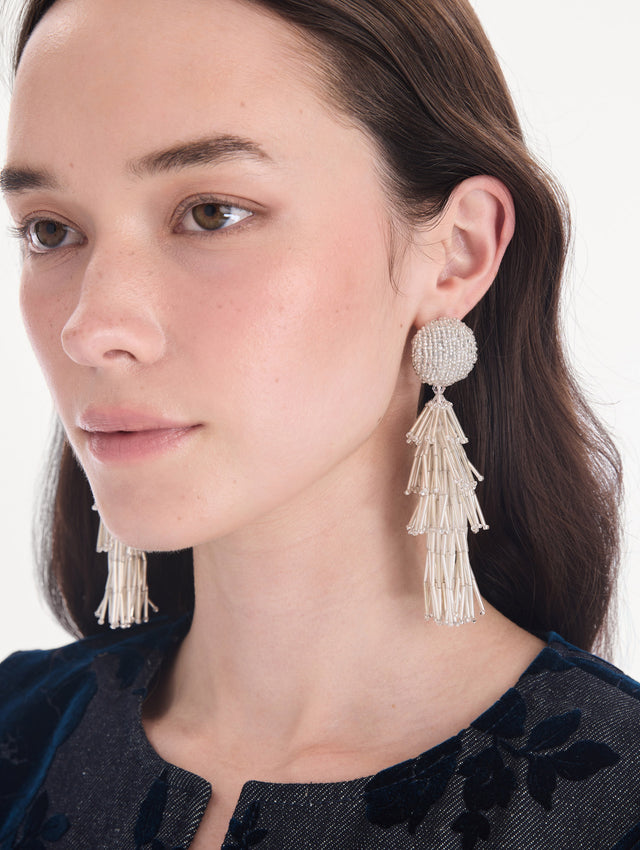 The model is wearing fringe tassel earrings. Front view.