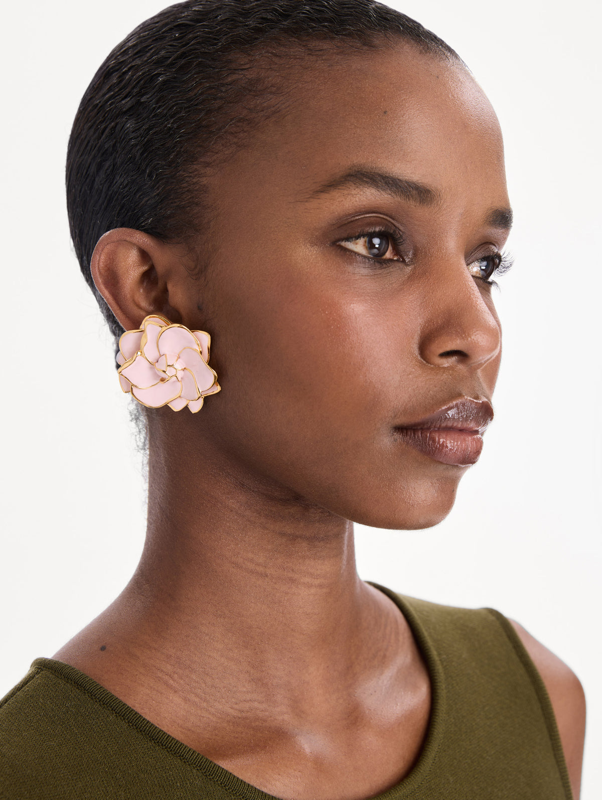 The model is wearing large painted gardenia earrings. Front view.