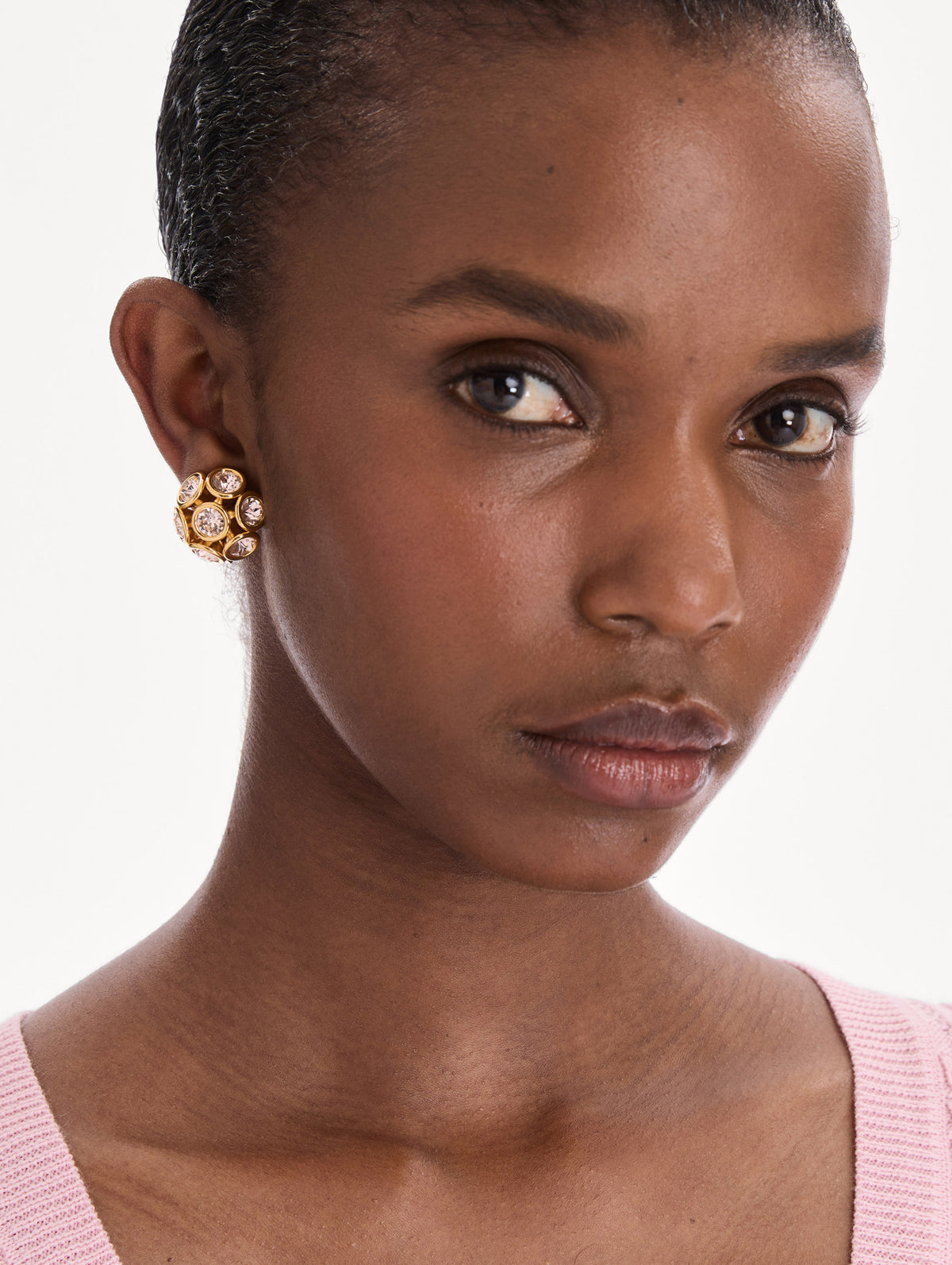 The model is wearing mini crystal cluster earrings. Front view.