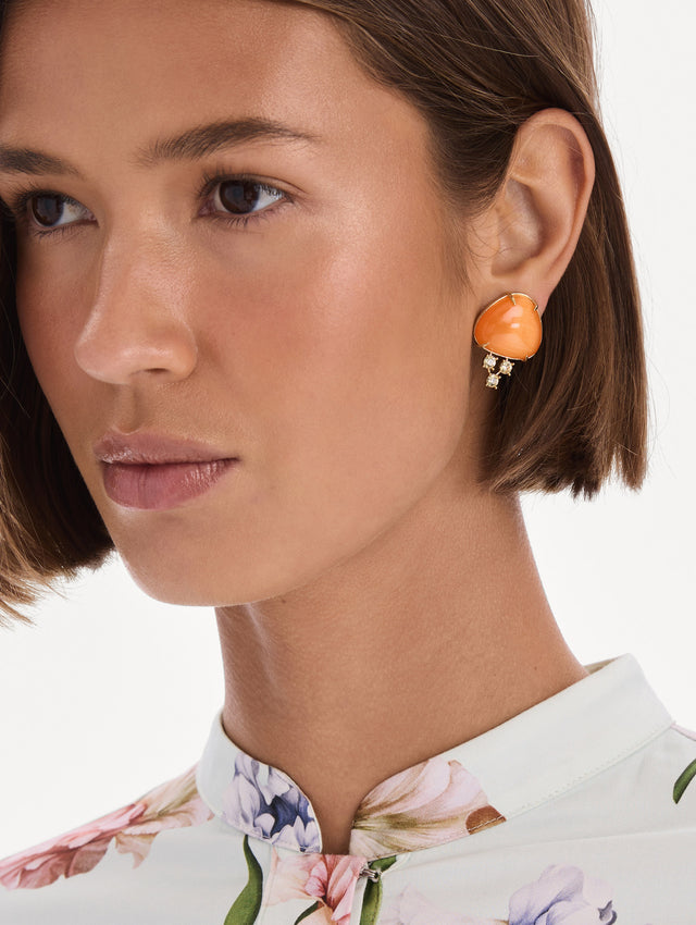 The model is wearing cabochon stud crystal earrings. Front view.
