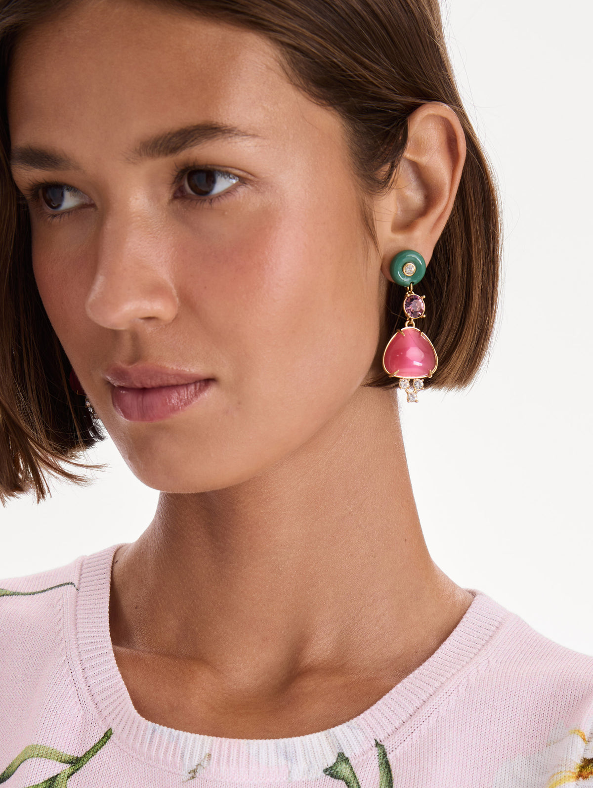 The model is wearing cabochon drop crystal earrings. Front view.