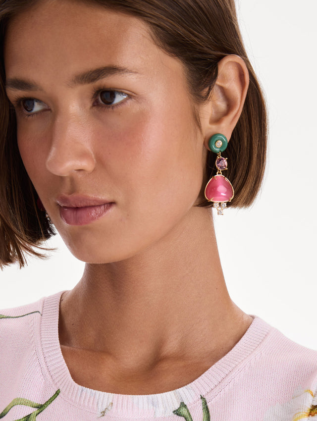 The model is wearing cabochon drop crystal earrings. Front view.