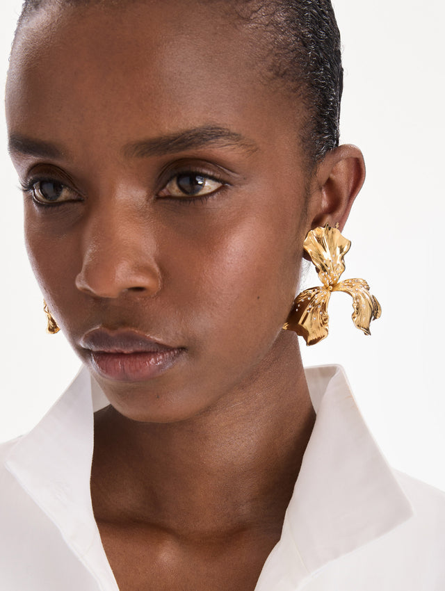 The model is wearing iris earrings. Front view.