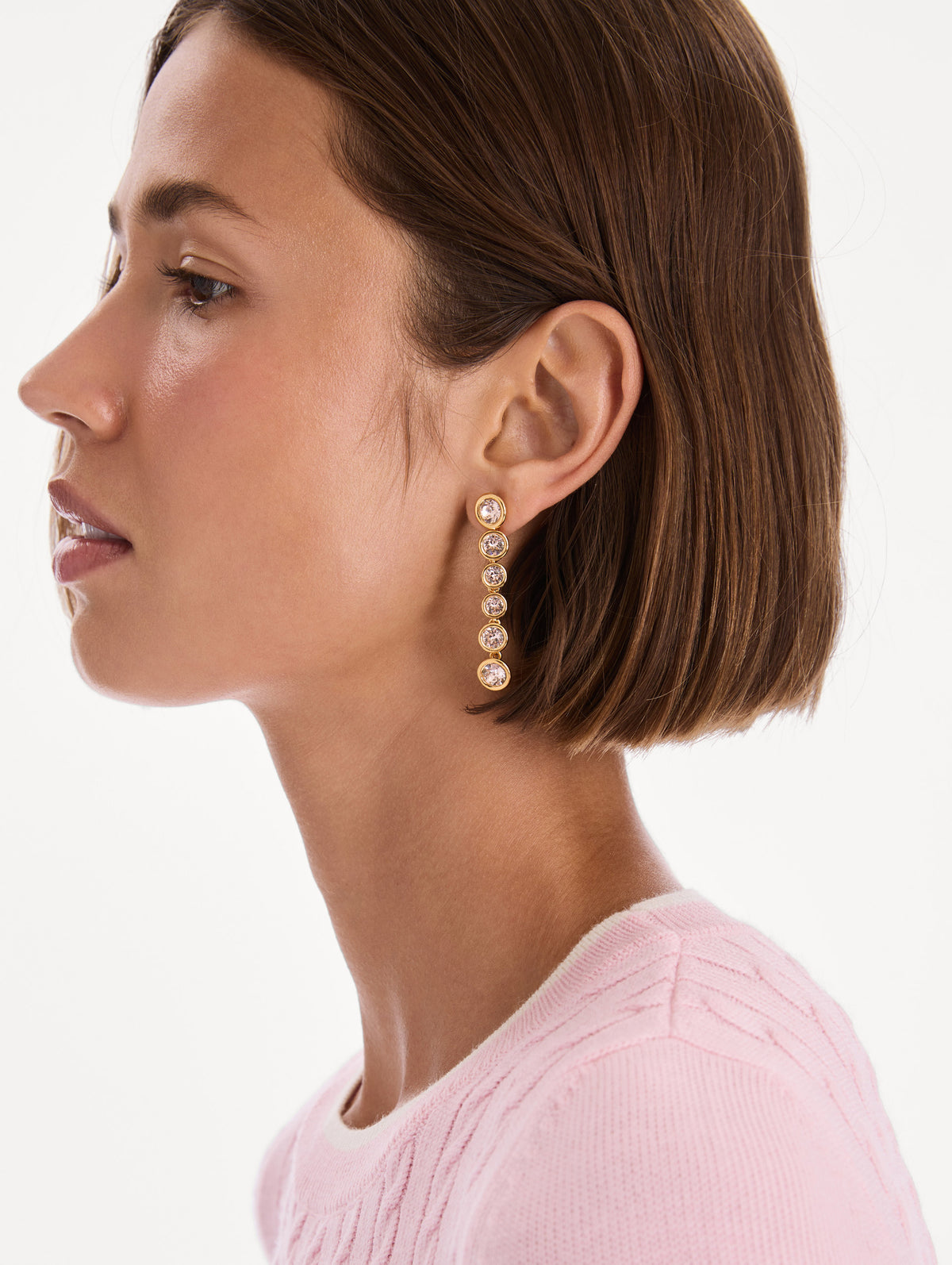 The model is wearing crystal sphere drop earrings. Front view.