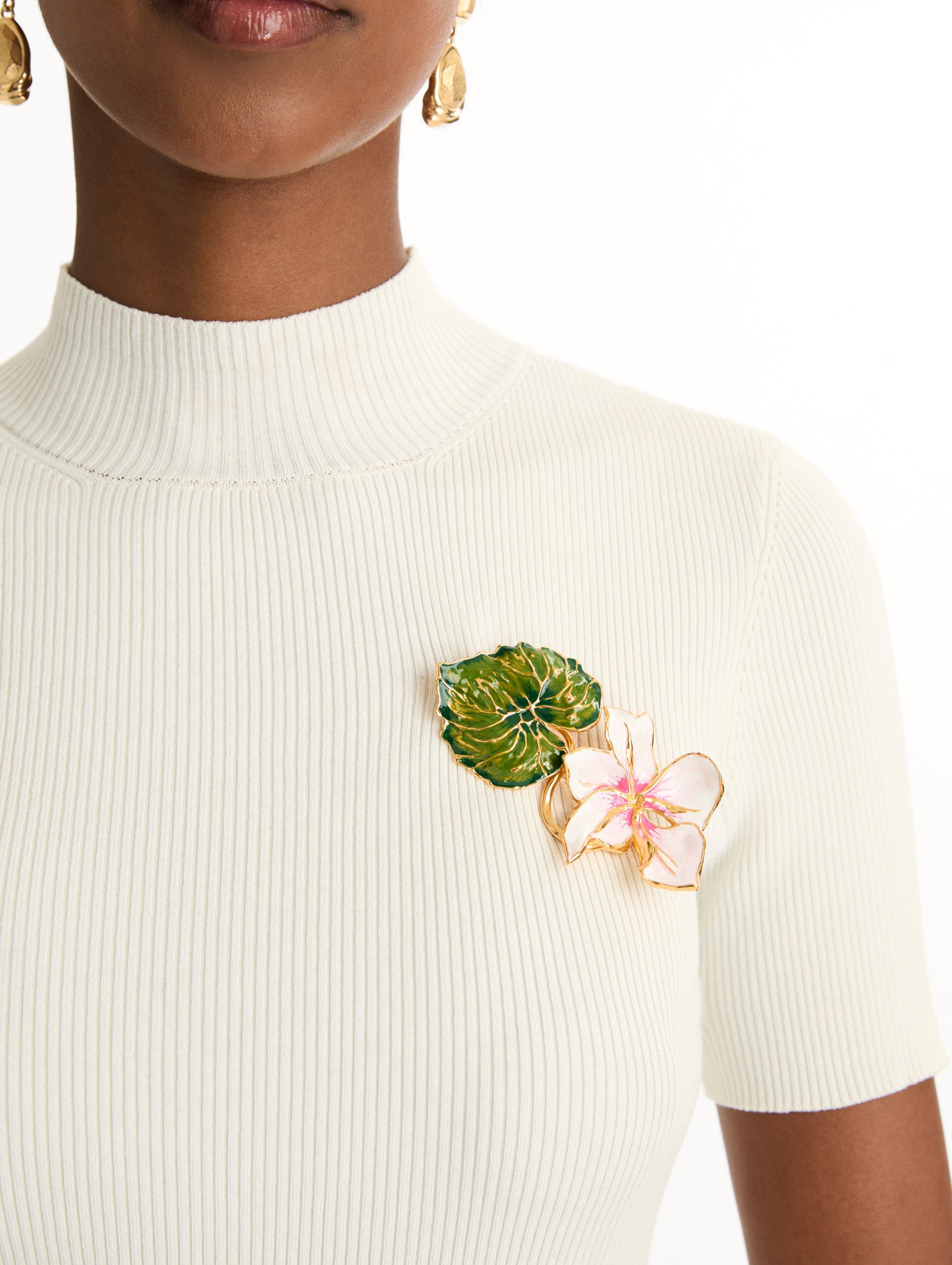 Gold Enamel Cyclamen Brooch with a green leaf and an extending pink flower. Front View.