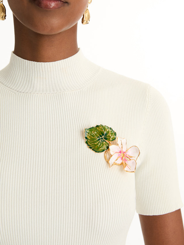 gold Enamel Cyclamen Brooch with a green leaf and an extending pink flower. Front View.