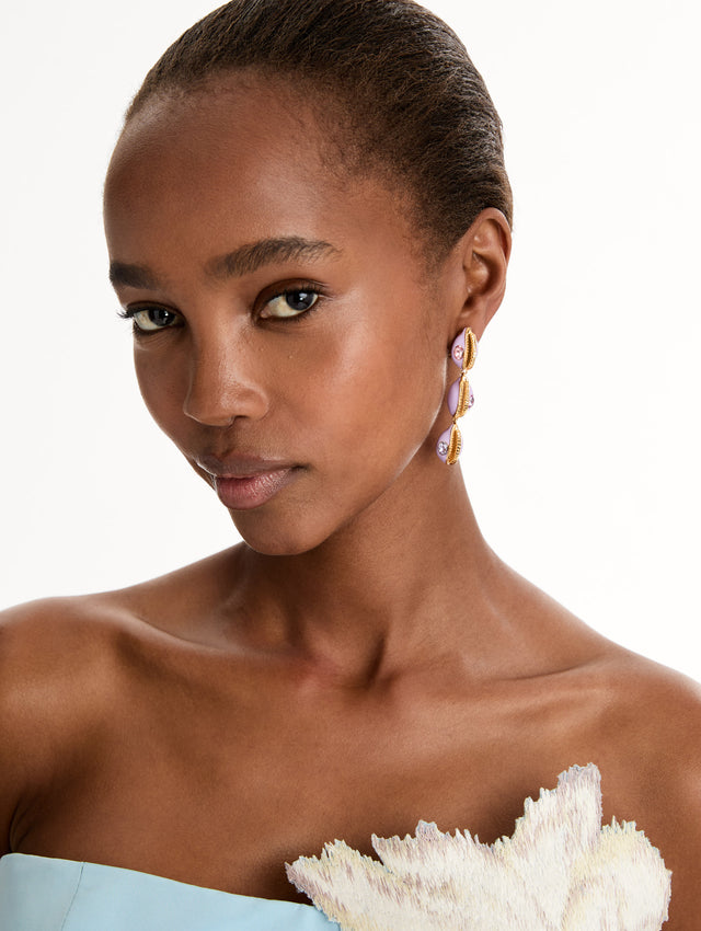 Gold and Purple Cowrie Shell Drop Clip-On Earrings featuring stacked shell motifs with pink and purple crystal accents. Side View. 