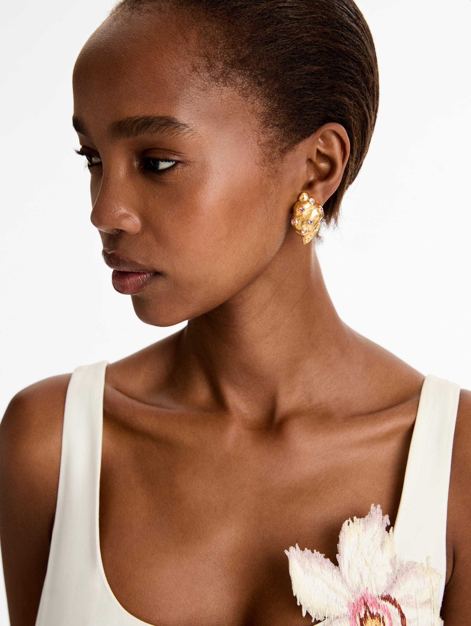 Gold Seashell Earrings with gold and purple gemstones. Side View.