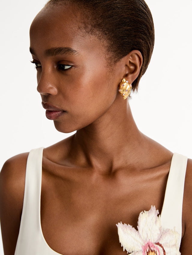 Gold Seashell Earrings with gold and purple gemstones. Side View.