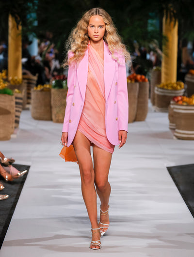 A model wears a pink tulle dress and pink blazer
