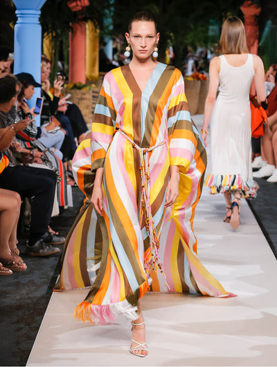 A model wears a striped caftan with string belt