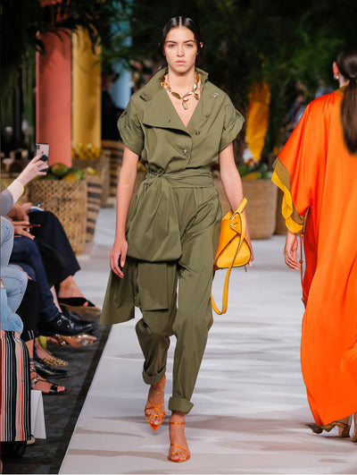 A model wears a military green pantsuit with bow belt