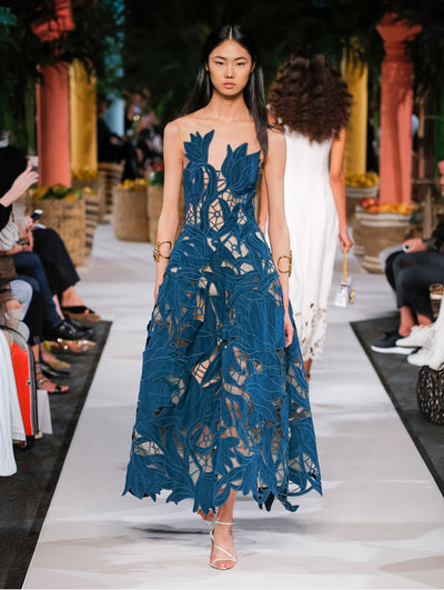 A model wears a lace navy gown