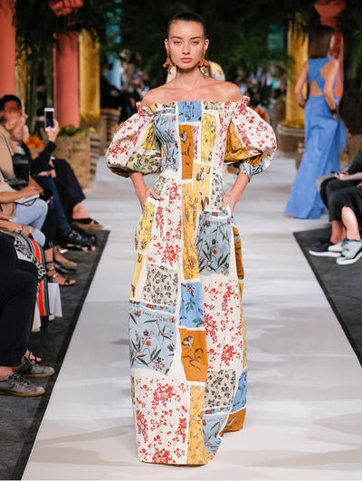 A model wears a multi-colored floral printed gown
