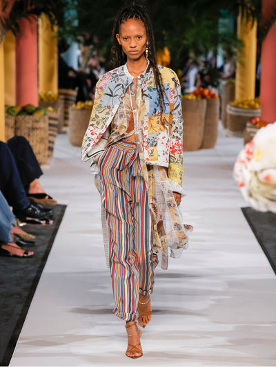 A model wears striped pants and floral printed top and jacket