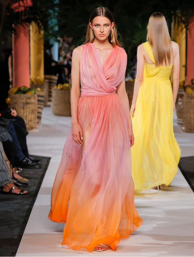 A model wears a pink tulle gown with orange at the bottom