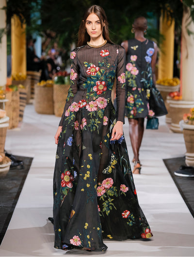 A model wears a black gown with colorful flowers printed