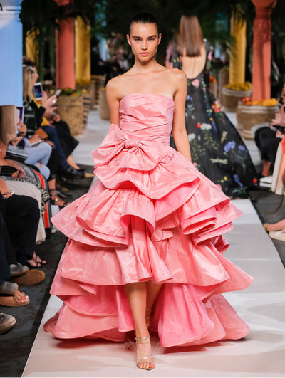 A model wears a pink ruffle gown