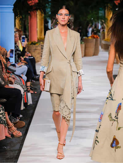 A model wears a khaki coat with flower embroidery at the bottom
